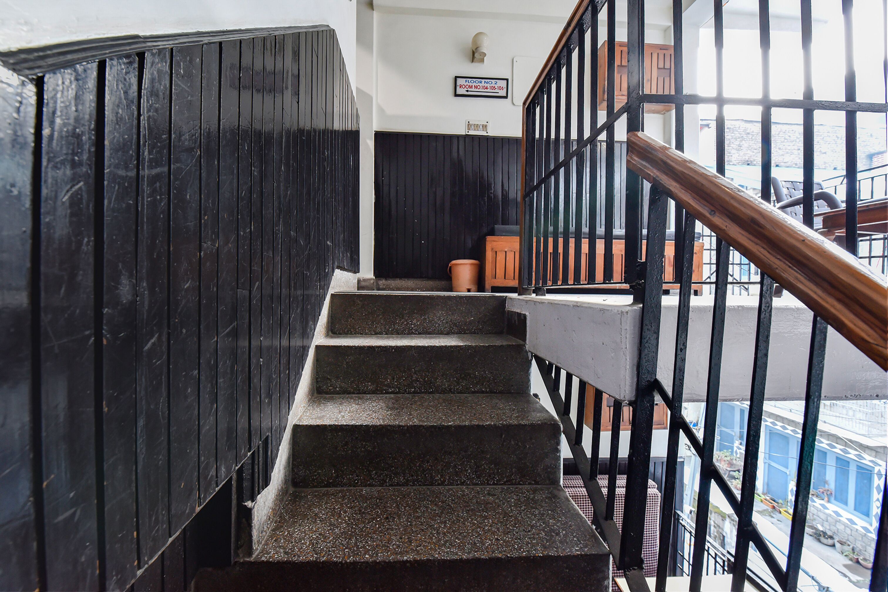 A staircase with black walls and a metal railing.