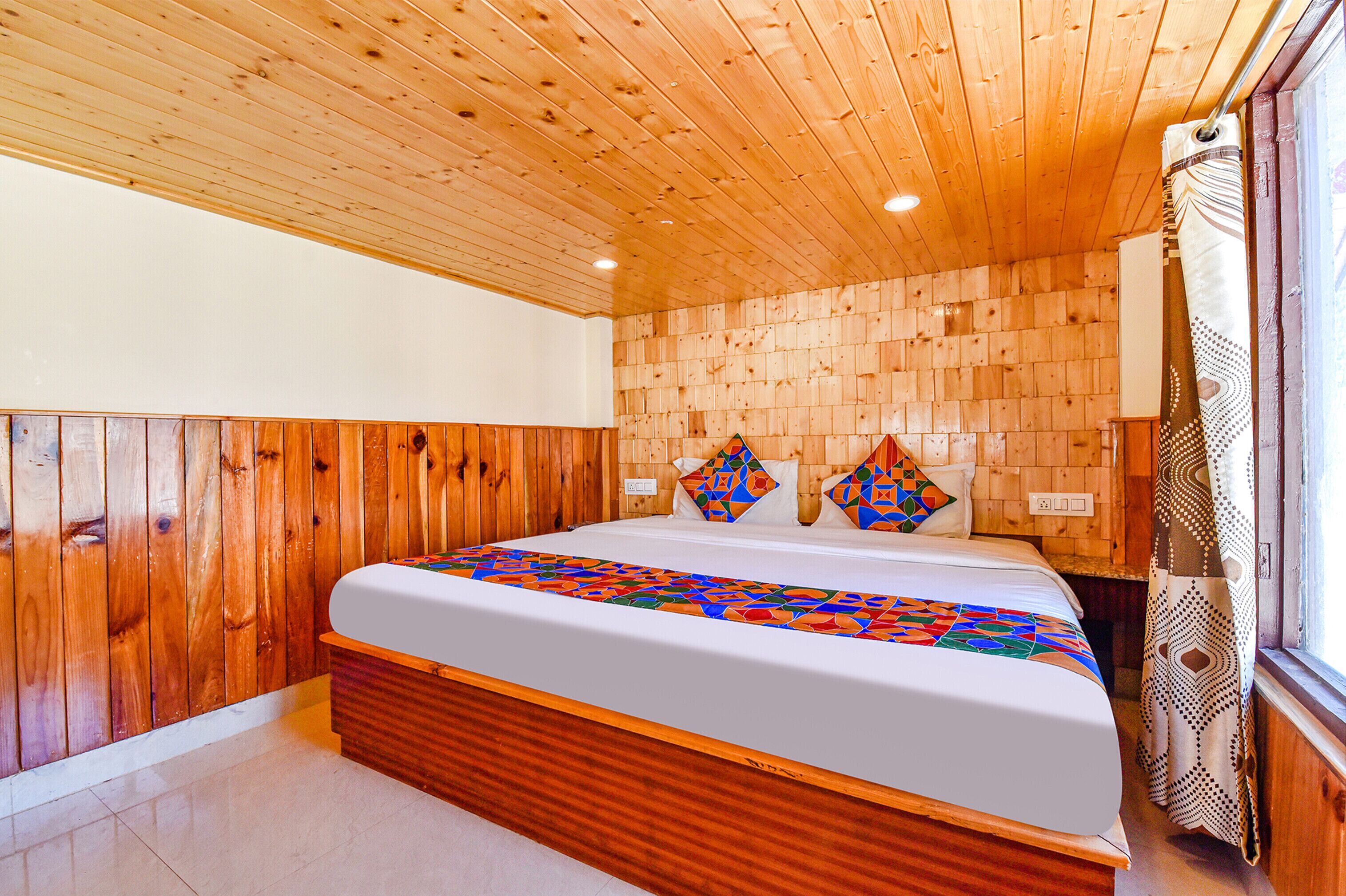 A wooden-paneled bedroom with a large bed, a wooden headboard, and a window with curtains.