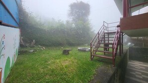 A grassy yard with a metal staircase leading to a building.