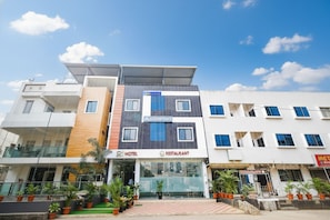 A modern hotel with a restaurant on the ground floor, featuring a glass facade and a flat roof. - Fabhotel Aashiyana (Indore)