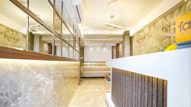 A hotel reception area with a marble floor, a reception desk, and a sign indicating the hotel name. - FabHotel Shubham Inn (Mumbai)
