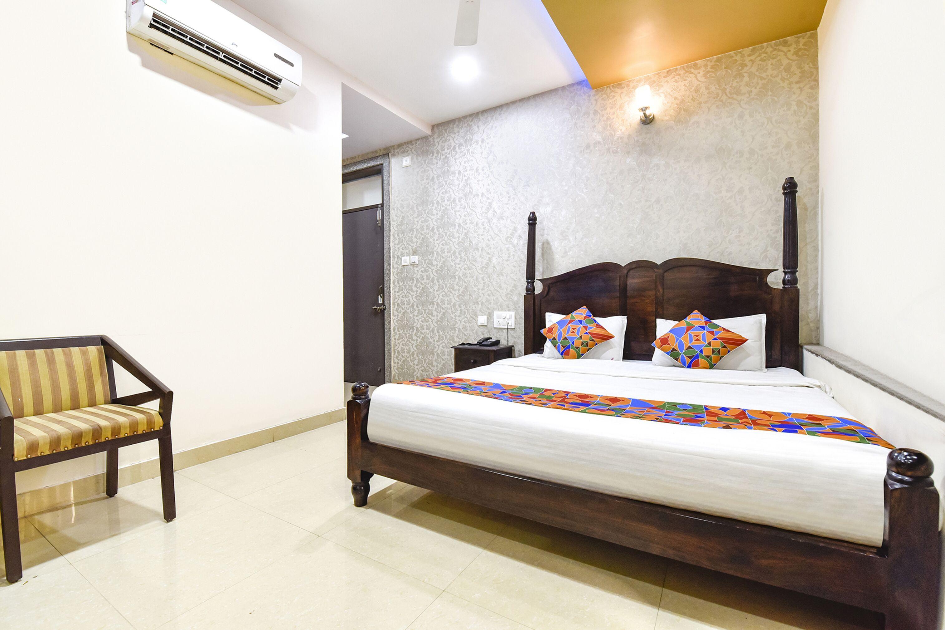 A neatly arranged bedroom with a wooden bed, a chair, and an air conditioning unit.
