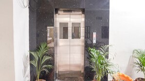 An elevator with a metallic finish, flanked by potted plants. - FabHotel Vairagi Inn - Nr. Bhojuveer Chauraha, Shivpur (Varanasi)