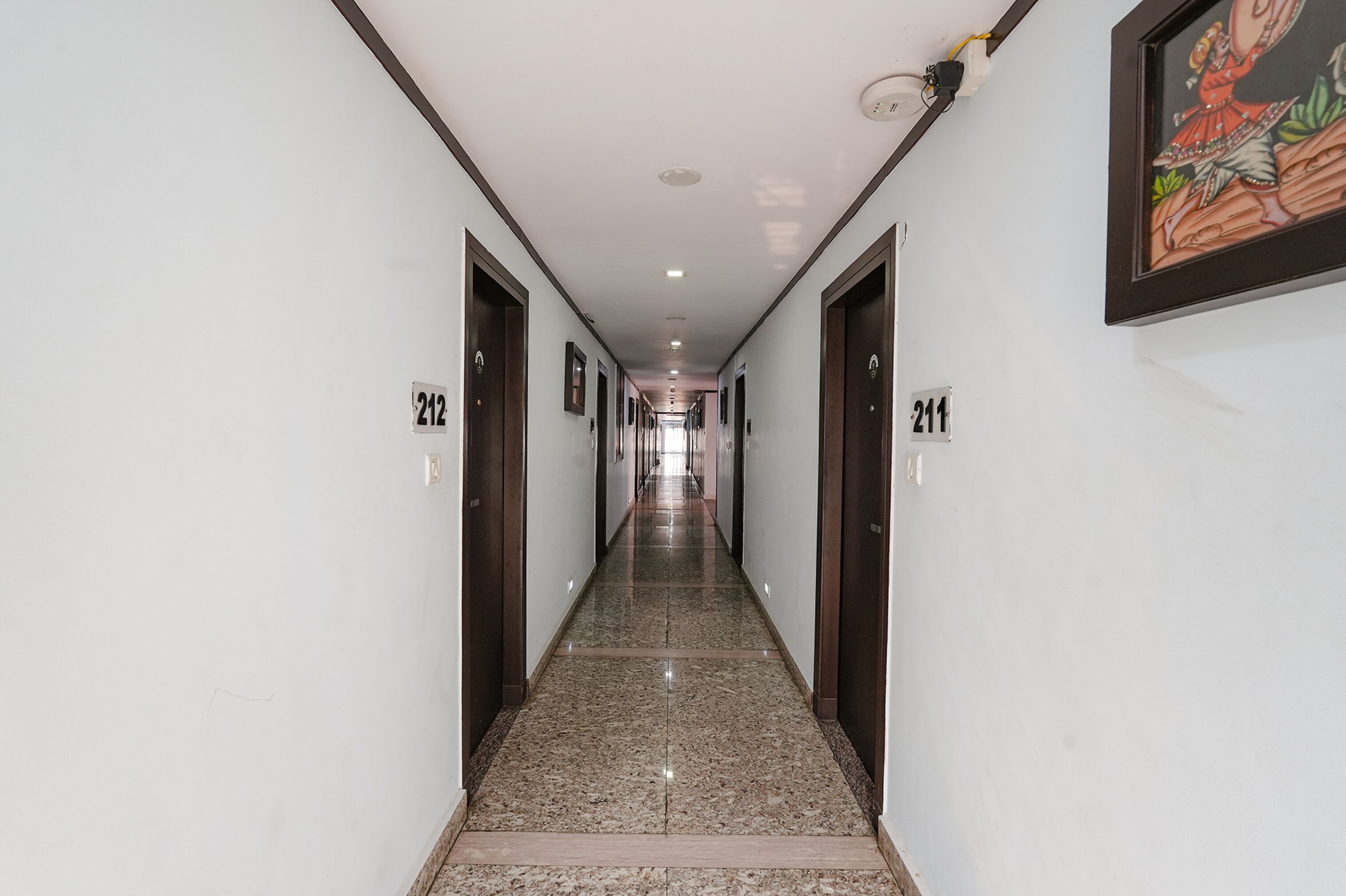 Un largo pasillo estrecho con puertas numeradas 212 y 211, que dan a habitaciones.