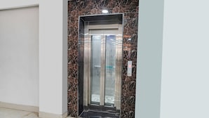 An elevator with a marble wall and a digital display. - Fabhotel Prime Stay Inn I (Varanasi)