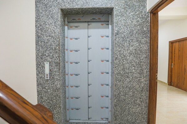 A hallway with a granite wall and a wooden door.
