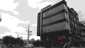 Un edificio de varios pisos con un diseño arquitectónico moderno, que presenta una puerta roja destacada en la planta baja.