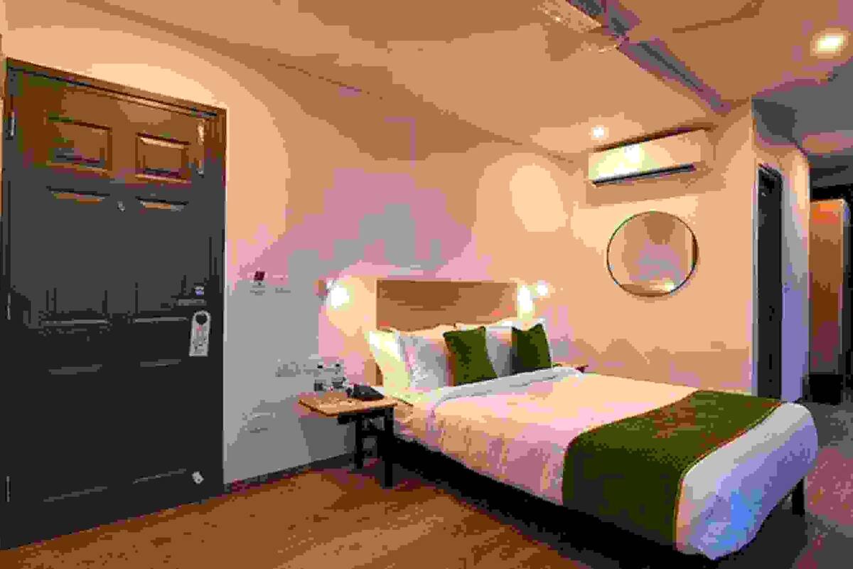 A modern bedroom with a bed, bedside table, and a door.