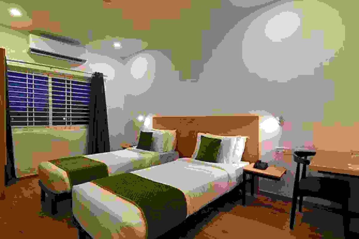 A pixelated room with two beds, a desk, and a chair.