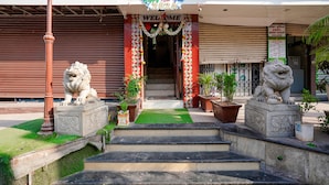 L'ingresso di un hotel con un cartello 'Welcome', una statua di leone a sinistra e un'altra a destra.