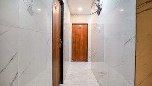 Un corridoio con pareti in marmo e una porta in legno in fondo.