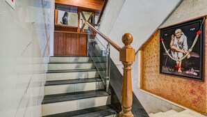 Una scala in marmo con gradini neri e una ringhiera in legno.
