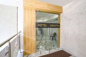 Entrada de hotel com chão de mármore e moldura de porta em madeira.