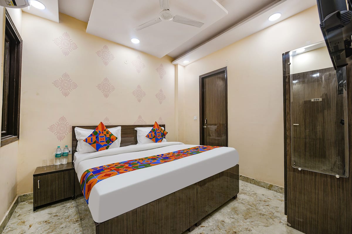 A hotel room with a bed, nightstand, wardrobe, and a ceiling fan.