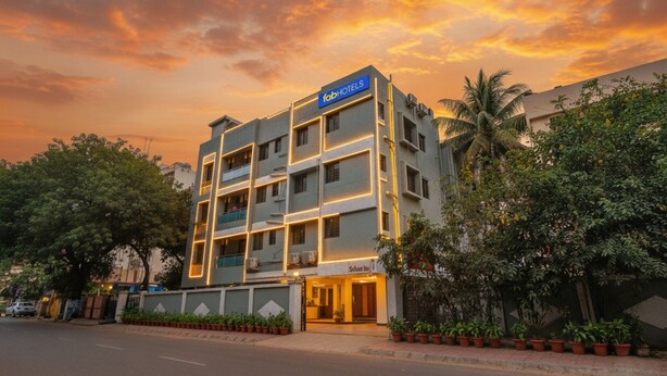 A modern hotel with a flat facade, multiple balconies, and a well-lit entrance. - Fabhotel Saffron Inn I (Pune)