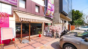A hotel entrance with a striped awning, a welcome sign, and a potted plant. - Fabhotel Dwarka Suites (New Delhi)