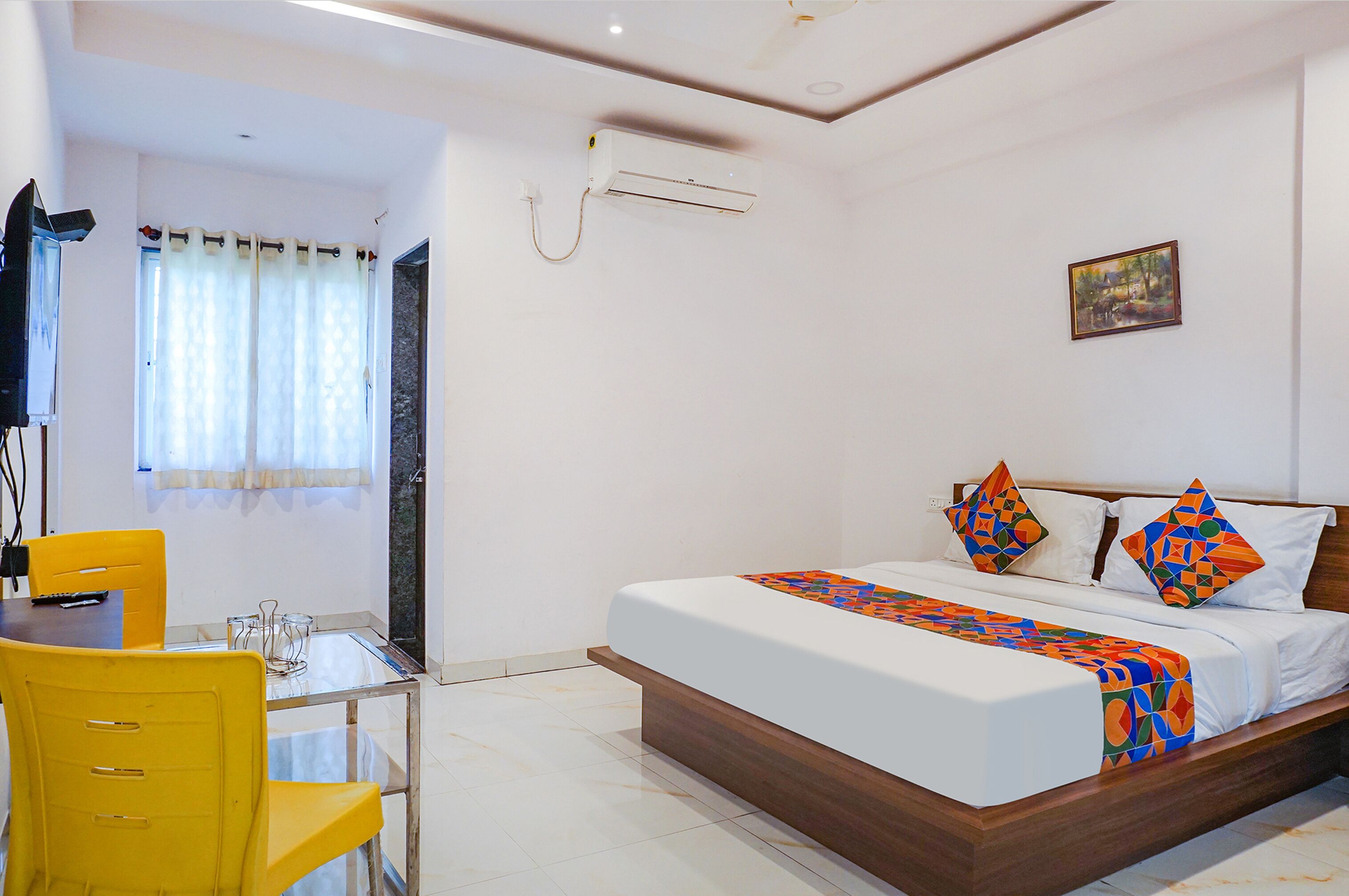 A bedroom with a bed, a desk, and a chair.