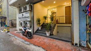 A hotel entrance with a sign reading "Royal Residency," a staircase leading inside, and a parked scooter. - Fabhotel Royal Residency I (New Delhi)
