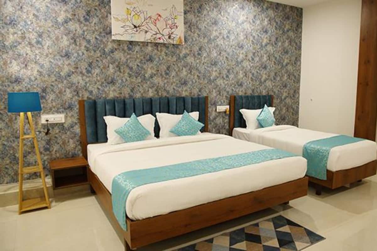 A double bed with a wooden frame and a headboard, two bedside tables, and a blue patterned rug.
