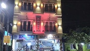 Un edificio con un letrero que dice "WALAJI INN" y un letrero que indica "Café Latte" debajo.