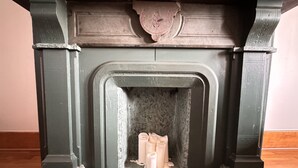 Una chimenea con revestimiento de piedra y un escudo decorativo encima.