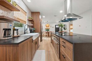Une cuisine moderne avec des meubles en bois, des appareils en acier inoxydable et un îlot central.