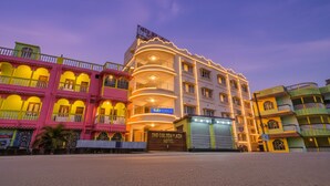 Een hotel met meerdere verdiepingen, balkons en een bord met de tekst Golden Plaza Hotel.