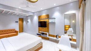 A modern hotel room with a bed, a sofa, a TV, a mirror, and a coffee machine. - Fabhotel Prime Opulence (Chhatrapati Sambhajinagar)