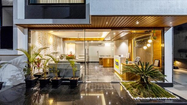 A modern hotel lobby with a reception desk, seating area, and potted plants. - Fabhotel Prime Opulence (Chhatrapati Sambhajinagar)