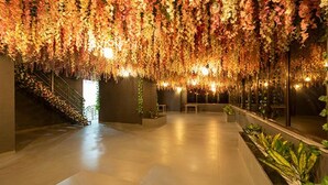 An indoor space with a staircase on the left, a bench in the center, and a wall with a reflective surface on the right. - Fabhotel Prime Opulence (Chhatrapati Sambhajinagar)