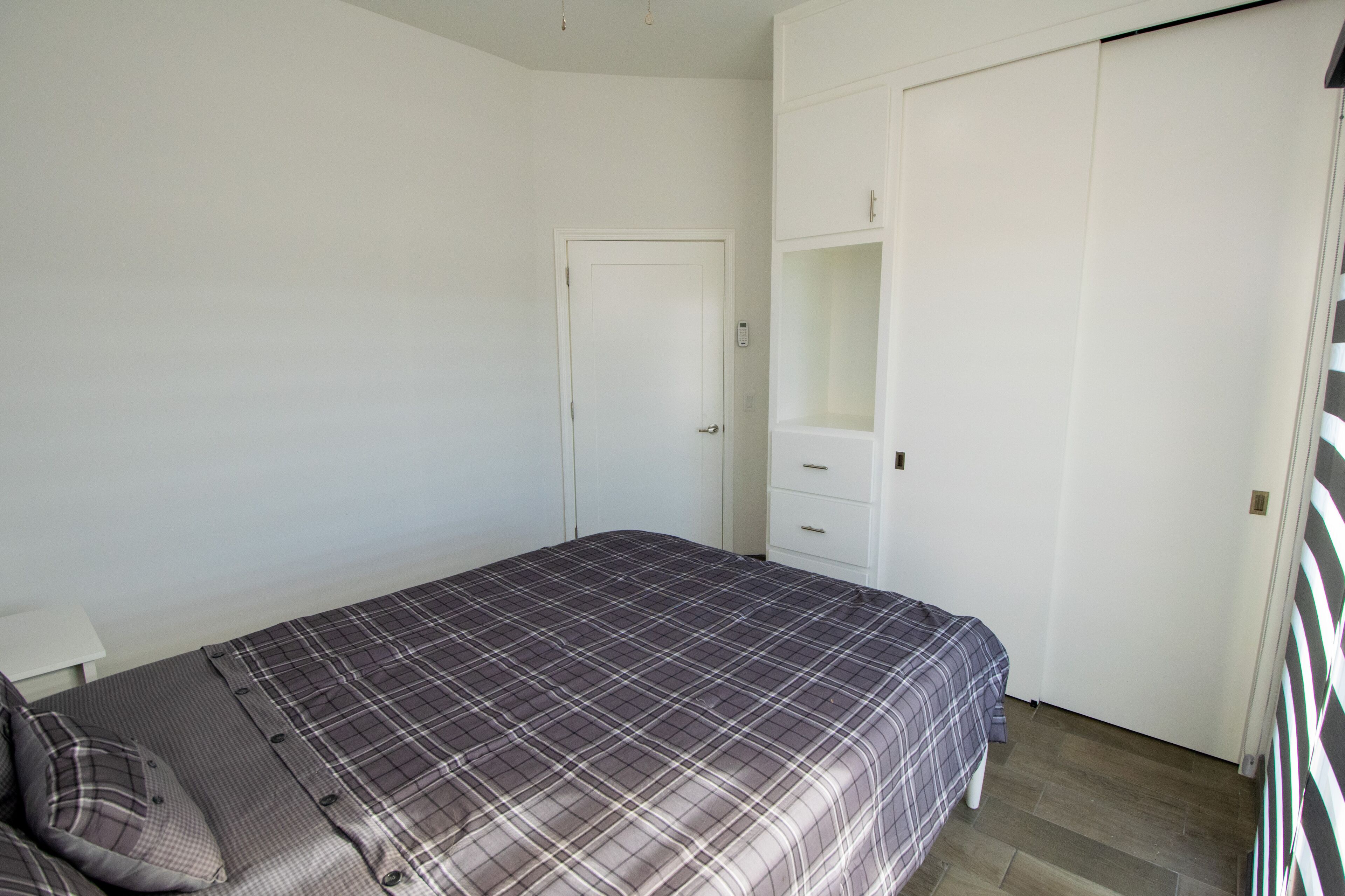 Ein Schlafzimmer mit einem Bett, einem Kleiderschrank und einem Nachttisch.