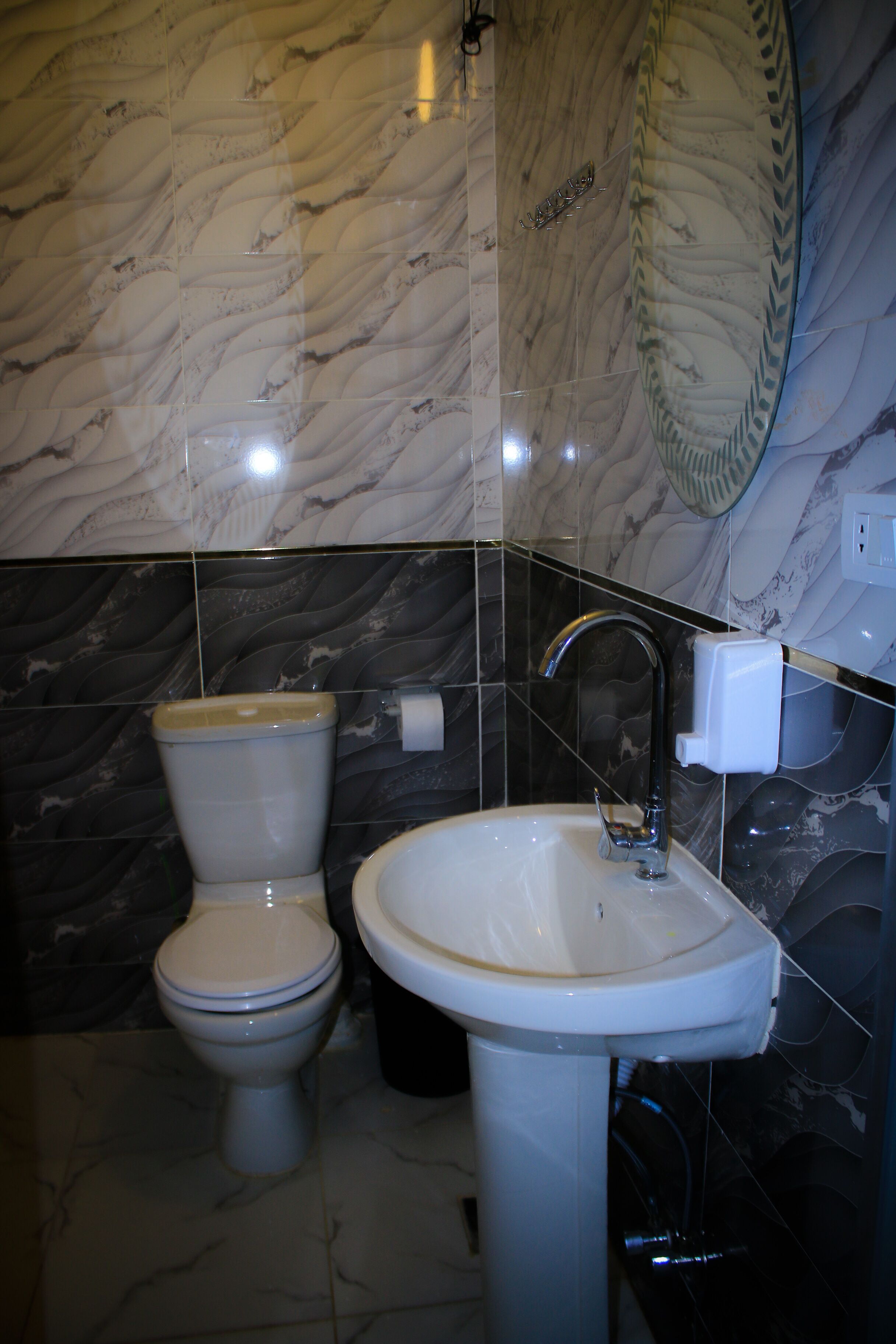 Ein Badezimmer mit Toilette, Waschbecken und Marmorwänden.