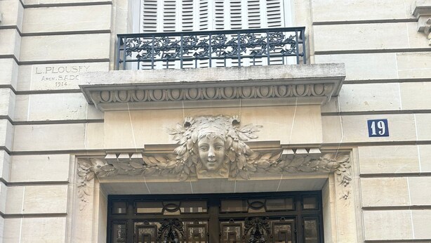 A building entrance with a black double door, a decorative stone facade, and a small balcony above. - Golden Triangle x Av Montagine & Champs Elysees (Paris)