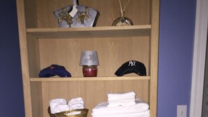 A wooden shelf with folded towels, a basket, a lamp, and a Mickey Mouse head. - UPSCALE NE TALLAHASSEE QUIET, SECURE RESIDENCE FULLY EQUIPPED (Tallahassee)