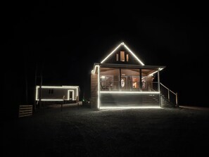 Een chalet met een veranda en een trap naar de ingang.
