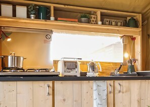 Eine Küche mit Holzschränken, einem Herd, einem Toaster und verschiedenen Küchengeräten.