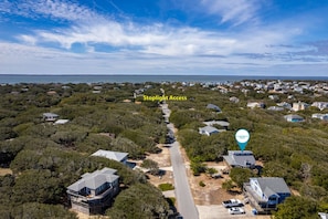 A coastal residential area with houses, a road, and a body of water.
