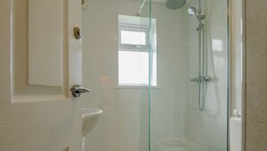 A bathroom with a glass shower enclosure, a toilet, and a sink. - Ground Floor Apartment (Pet) (Ingoldmells, Skegness)
