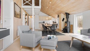 A modern interior with a dining area, kitchen, and a fireplace.