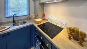 A modern kitchen with a sink, stove, and window. - Relax and unwind in the perfect hideout. (Snowdonia)