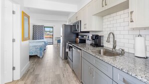 Una cocina moderna con encimeras de granito, electrodomésticos de acero inoxidable y armarios blancos.