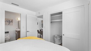 Una habitación de hotel con cama, baño, escritorio y armario.