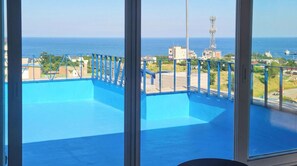 Een balkon met uitzicht op zee en gebouwen.