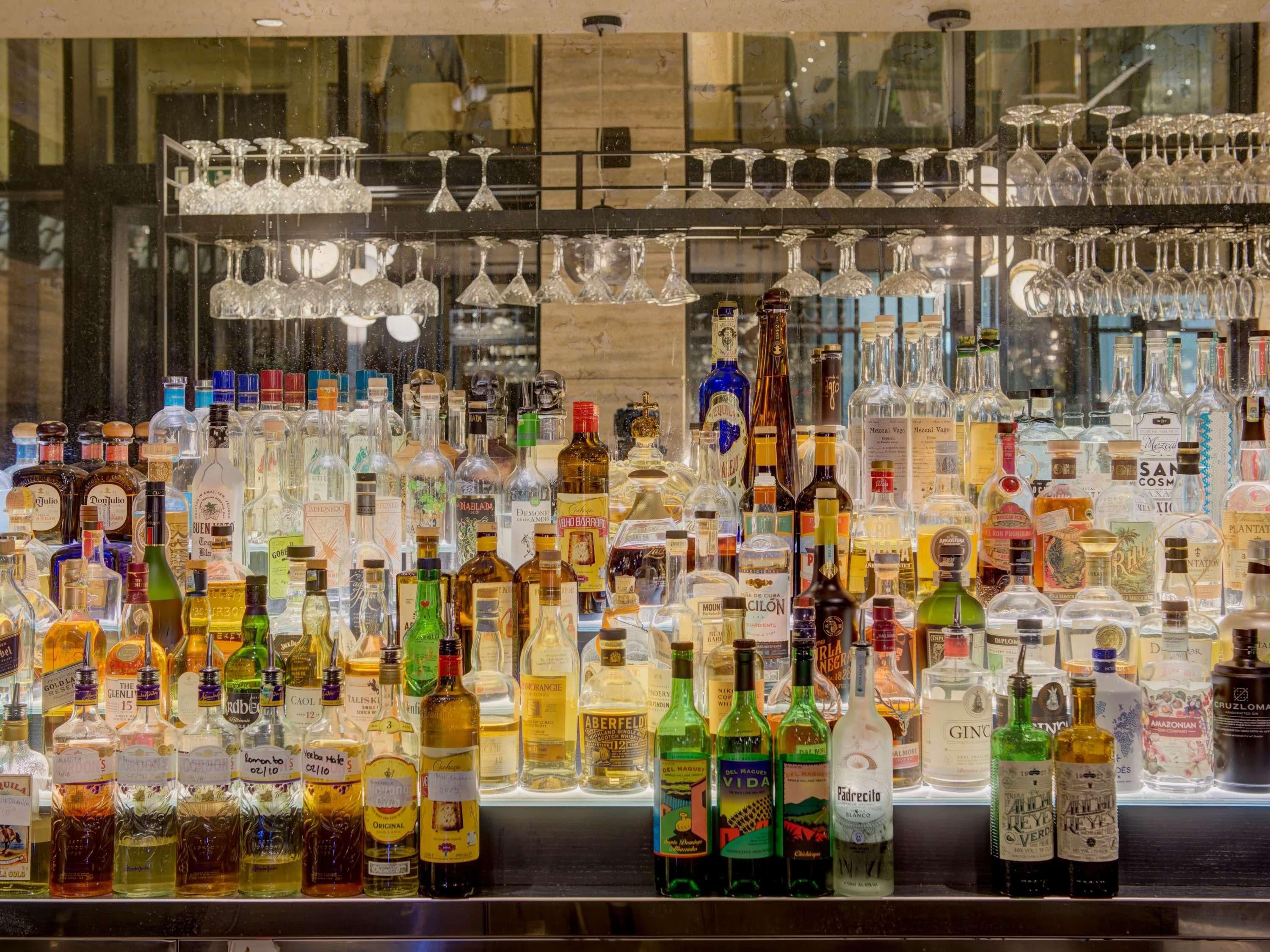Eine Bar mit einer Auswahl an Spirituosenflaschen und Gläsern.