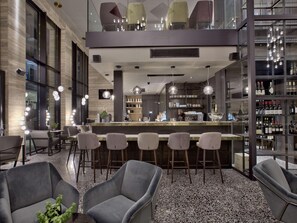 Un espace bar moderne avec des tabourets, un comptoir et un présentoir à bouteilles de vin.