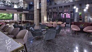 A modern interior with seating areas, a central table, and hanging light fixtures.
