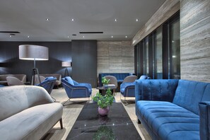 Ein stilvoller Loungesessel mit Sofas, Sesseln, einem Couchtisch und einer Stehlampe.