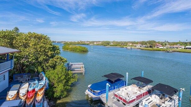 A waterfront property with a dock, kayaks, and a boat. - Caddy's #5 – Waterfront Balcony, Walk to Beach, Pet-Friendly & Next to Dining (Indian Shores)