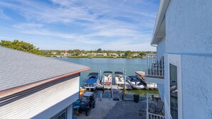 A marina with boats docked, a clear sky, and a view of a residential area in the background.