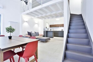 Ein modernes Interieur mit Essbereich, Treppe und Küche.